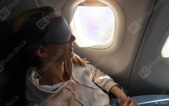 Woman with sleep mask on airplane leaning back in seat, lit by window light  : Stock Photo or Stock Video Download rcfotostock photos, images and assets rcfotostock | RC Photo Stock.: