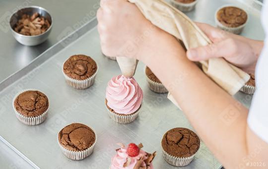 women in pastry bakery as confectioner glazing muffins with icing bag  : Stock Photo or Stock Video Download rcfotostock photos, images and assets rcfotostock | RC Photo Stock.: