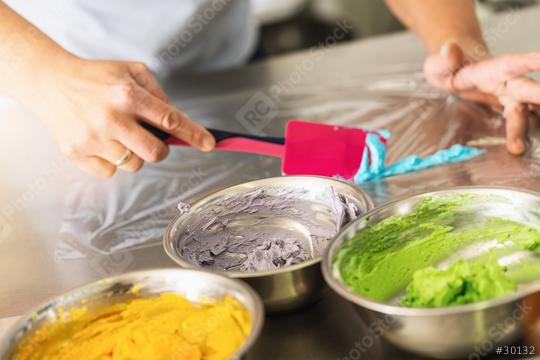 women in pastry bakery as confectioner prepares different cream colors for the icing bag to pipe muffin topping  : Stock Photo or Stock Video Download rcfotostock photos, images and assets rcfotostock | RC Photo Stock.: