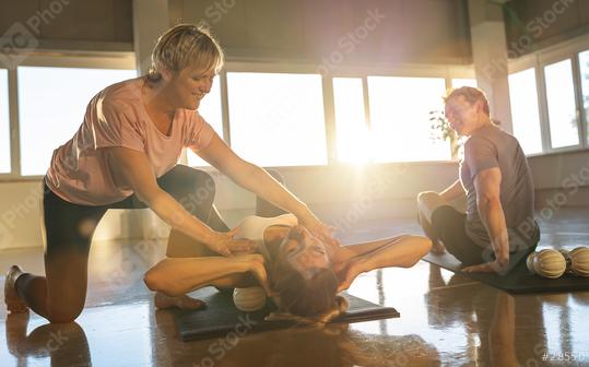 Yoga instructor assisting a student with stretching and massage ball in a sunlit room  : Stock Photo or Stock Video Download rcfotostock photos, images and assets rcfotostock | RC Photo Stock.: