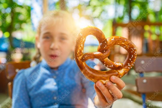 Youn girl holding Traditional Bavaria pretzel in Tracht, Dirndl having fun in Beer garden or oktoberfest in Bavaria, Germany  : Stock Photo or Stock Video Download rcfotostock photos, images and assets rcfotostock | RC Photo Stock.: