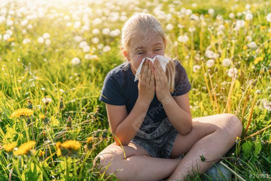 young girl sitting in a sunny field full of dandelions, holding a handkerchief to her nose, showing signs of allergy to pollen and grasses in spring. The sun is shining brightly on warm spring day  : Stock Photo or Stock Video Download rcfotostock photos, images and assets rcfotostock | RC Photo Stock.: