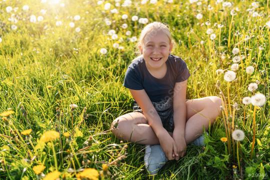 young girl sitting in a sunny field full of dandelions, smiling happily. The sun is shining brightly, creating a warm and vibrant atmosphere, capturing the joy of nature and childhood.  : Stock Photo or Stock Video Download rcfotostock photos, images and assets rcfotostock | RC Photo Stock.: