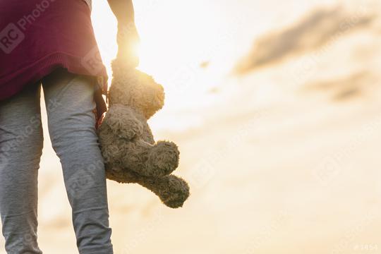 Young Girl standin through a sunset and Carrying a Teddy Bear  : Stock Photo or Stock Video Download rcfotostock photos, images and assets rcfotostock | RC Photo Stock.:
