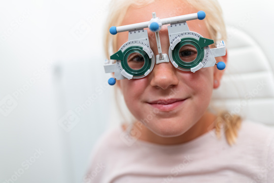 Young girl wearing trial frame glasses during an optometrist. ha  : Stock Photo or Stock Video Download rcfotostock photos, images and assets rcfotostock | RC Photo Stock.: