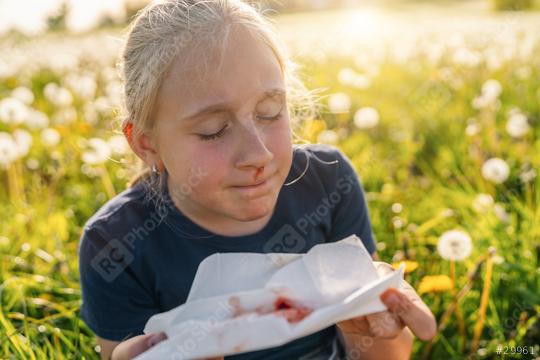 young girl with a nosebleed holding a blood-stained tissue while sitting in a field of dandelions, looking distressed. The image captures the outdoor setting and the health concern.  : Stock Photo or Stock Video Download rcfotostock photos, images and assets rcfotostock | RC Photo Stock.: