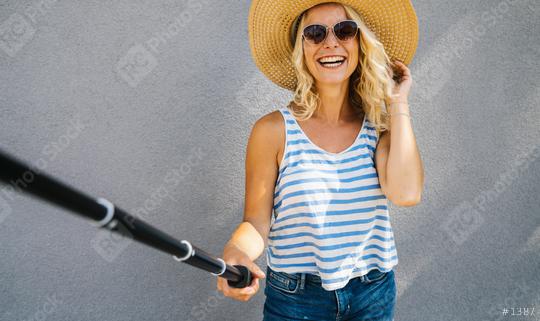 Young girl with straw hat smiling and use selfie stick to take a selfie, on summer in city street. Urban life concept image  : Stock Photo or Stock Video Download rcfotostock photos, images and assets rcfotostock | RC Photo Stock.: