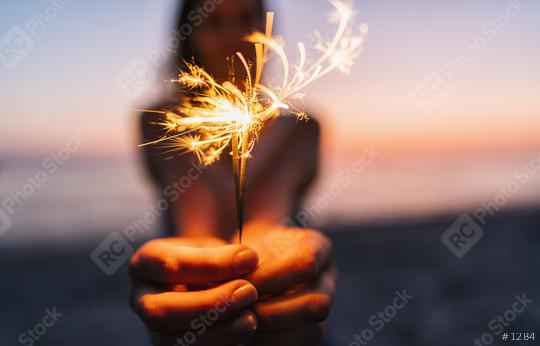 Young happy woman stands on beach with sparkler in sunset light  : Stock Photo or Stock Video Download rcfotostock photos, images and assets rcfotostock | RC Photo Stock.: