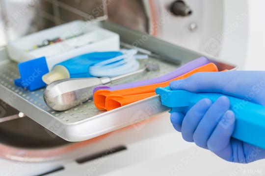 Young male dentist places medical autoclave for sterilising surgical and other instruments  : Stock Photo or Stock Video Download rcfotostock photos, images and assets rcfotostock | RC Photo Stock.: