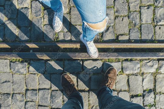 young man and a girl in sneakers stands opposite on cobblestones on a train track, high angle footsie or flortrait, personal pespective from above.  : Stock Photo or Stock Video Download rcfotostock photos, images and assets rcfotostock | RC Photo Stock.: