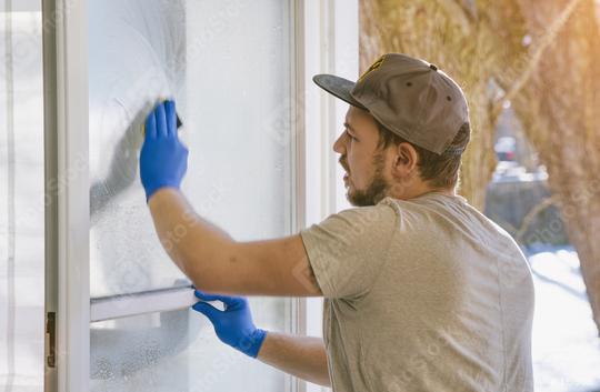 young man is using a rag and squeegee while cleaning windows.  : Stock Photo or Stock Video Download rcfotostock photos, images and assets rcfotostock | RC Photo Stock.: