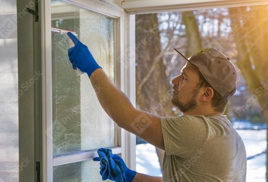 young man is using a rag and squeegee while cleaning windows.  : Stock Photo or Stock Video Download rcfotostock photos, images and assets rcfotostock | RC Photo Stock.: