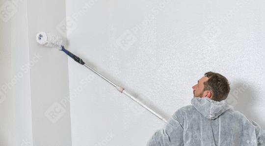 young painter working with paint roller to paint the wall of a room. do it yourself concept image with copy space  : Stock Photo or Stock Video Download rcfotostock photos, images and assets rcfotostock | RC Photo Stock.: