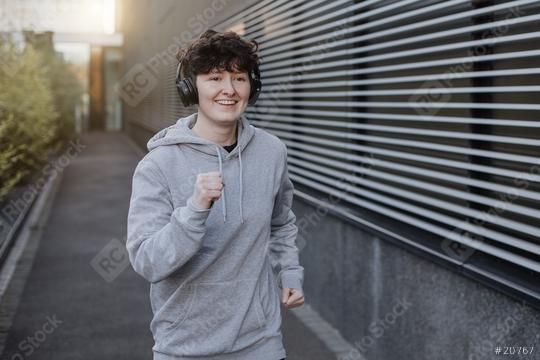 young person runs and makes fitness workout for good health and listing to music on earphones   : Stock Photo or Stock Video Download rcfotostock photos, images and assets rcfotostock | RC Photo Stock.: