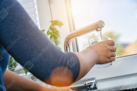young woman gaining a glass of clean tap water in the kitchen in front of the window  : Stock Photo or Stock Video Download rcfotostock photos, images and assets rcfotostock | RC Photo Stock.: