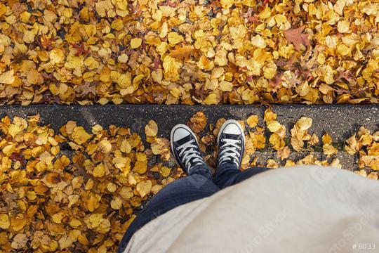 Young woman in sneakers stands in at a curbstone with foliage leafs at autumn on the streets, personal pespective from above.  : Stock Photo or Stock Video Download rcfotostock photos, images and assets rcfotostock | RC Photo Stock.:
