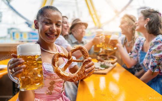 Young woman joyfully holding a beer mug and a pretzel in a beer tent, at Oktoberfest or dult in germany  : Stock Photo or Stock Video Download rcfotostock photos, images and assets rcfotostock | RC Photo Stock.: