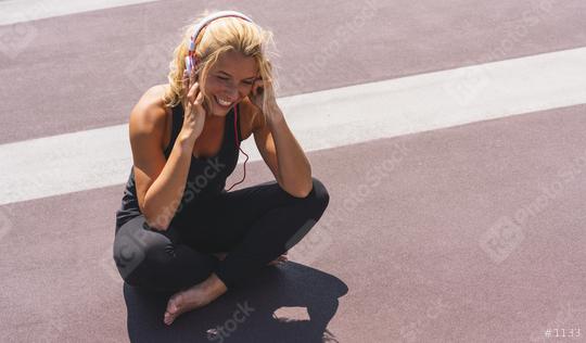 Young woman listening to music with earphones for fitness motivation. Portrait of a smiling young woman in sportswear relaxing sitting getting inspired. copyspace for your individual text.  : Stock Photo or Stock Video Download rcfotostock photos, images and assets rcfotostock | RC Photo Stock.: