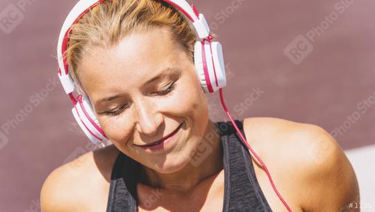 Young woman listening to music with earphones for fitness motivation. Portrait of a young woman in sportswear relaxing sitting getting inspired.  : Stock Photo or Stock Video Download rcfotostock photos, images and assets rcfotostock | RC Photo Stock.: