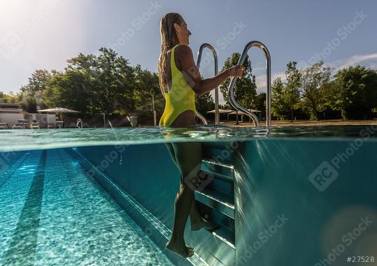 young woman stands by a ladder in a swimming pool, Split above and underwater photo   : Stock Photo or Stock Video Download rcfotostock photos, images and assets rcfotostock | RC Photo Stock.: