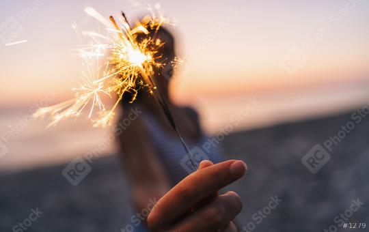 Young woman stands on beach with sparkler in sunset light  : Stock Photo or Stock Video Download rcfotostock photos, images and assets rcfotostock | RC Photo Stock.: